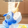 A blue electric fishing toy with a head and mouth is shown dipping into water, demonstrating magnetic adhesion.
