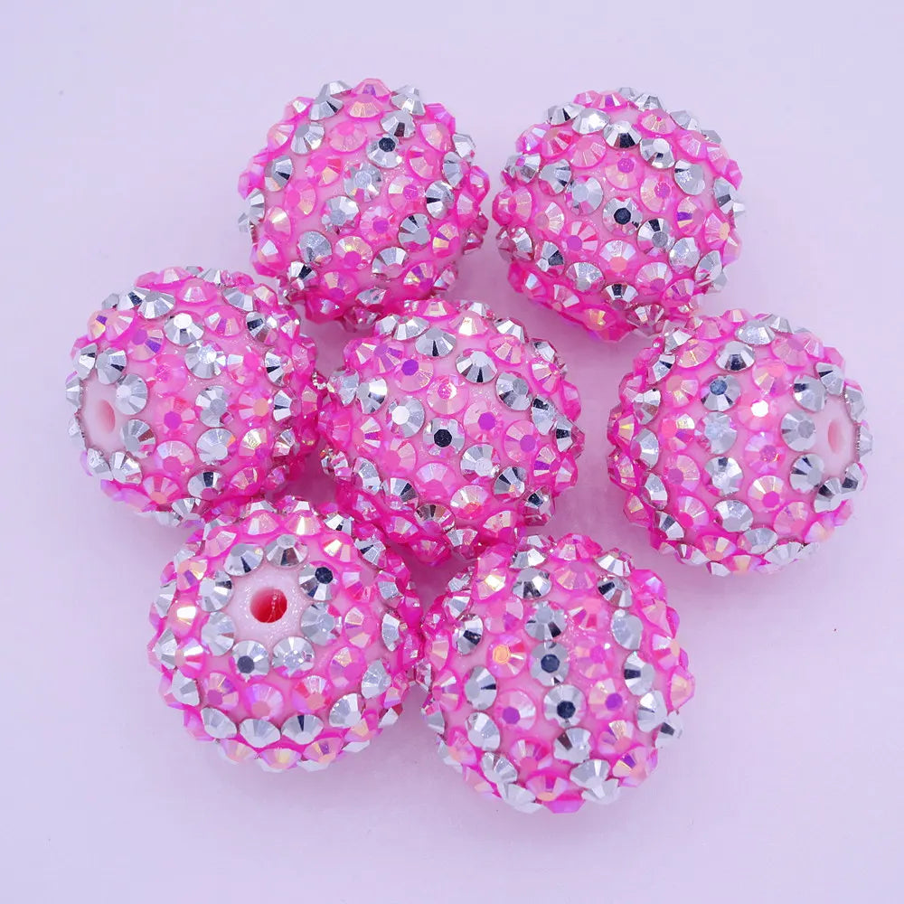 A collection of ten pink and silver glitter resin beads for jewelry making