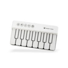 A white 7-key mini electronic keyboard piano with indicator lights.