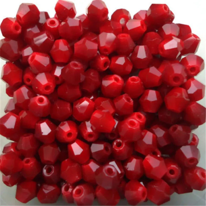 A pile of faceted red glass bicone beads for jewelry making