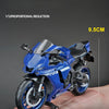 A blue 1:12 scale diecast model of a Yamaha YZF-R1M motorcycle is shown being held in a hand.