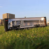 A 1:50 scale diecast alloy container truck model displayed on green grass.