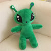 An adorable green alien plush toy with long ears sitting on a light-colored surface.