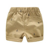 Tan boys cotton beach shorts featuring a subtle anchor print