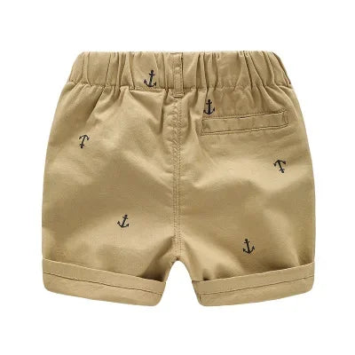 Tan boys cotton beach shorts featuring a subtle anchor print
