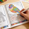 A hand colors a detailed bird illustration in a coloring book featuring nature patterns and a color palette.
