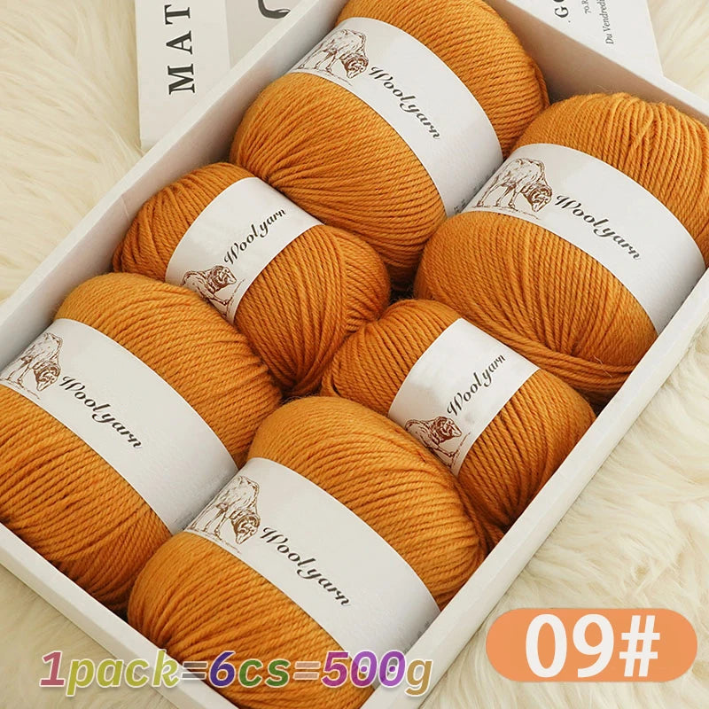 A box filled with nine balls of orange wool yarn labeled Woolyarn for knitting