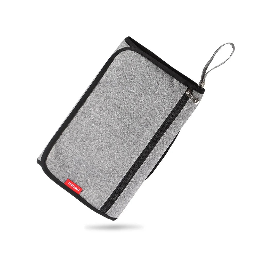A gray portable baby changing mat with a storage bag and drawstring closure.