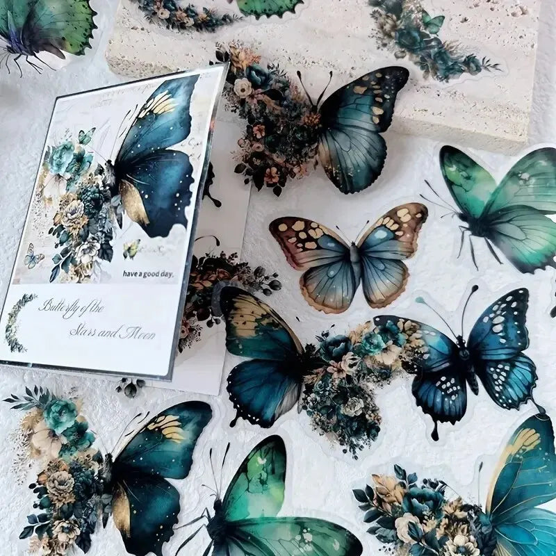 A collection of decorative stickers featuring butterflies and floral elements in shades of blue, green, and gold.