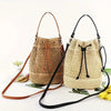 A beige crochet dumpling bag with black hardware and adjustable strap displayed on a white background.