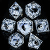 A set of clear, faceted resin dice shaped like tetrahedrons and dodecahedrons for tabletop role-playing games
