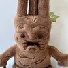 A brown Mandrake plush toy with textured skin and small facial features.