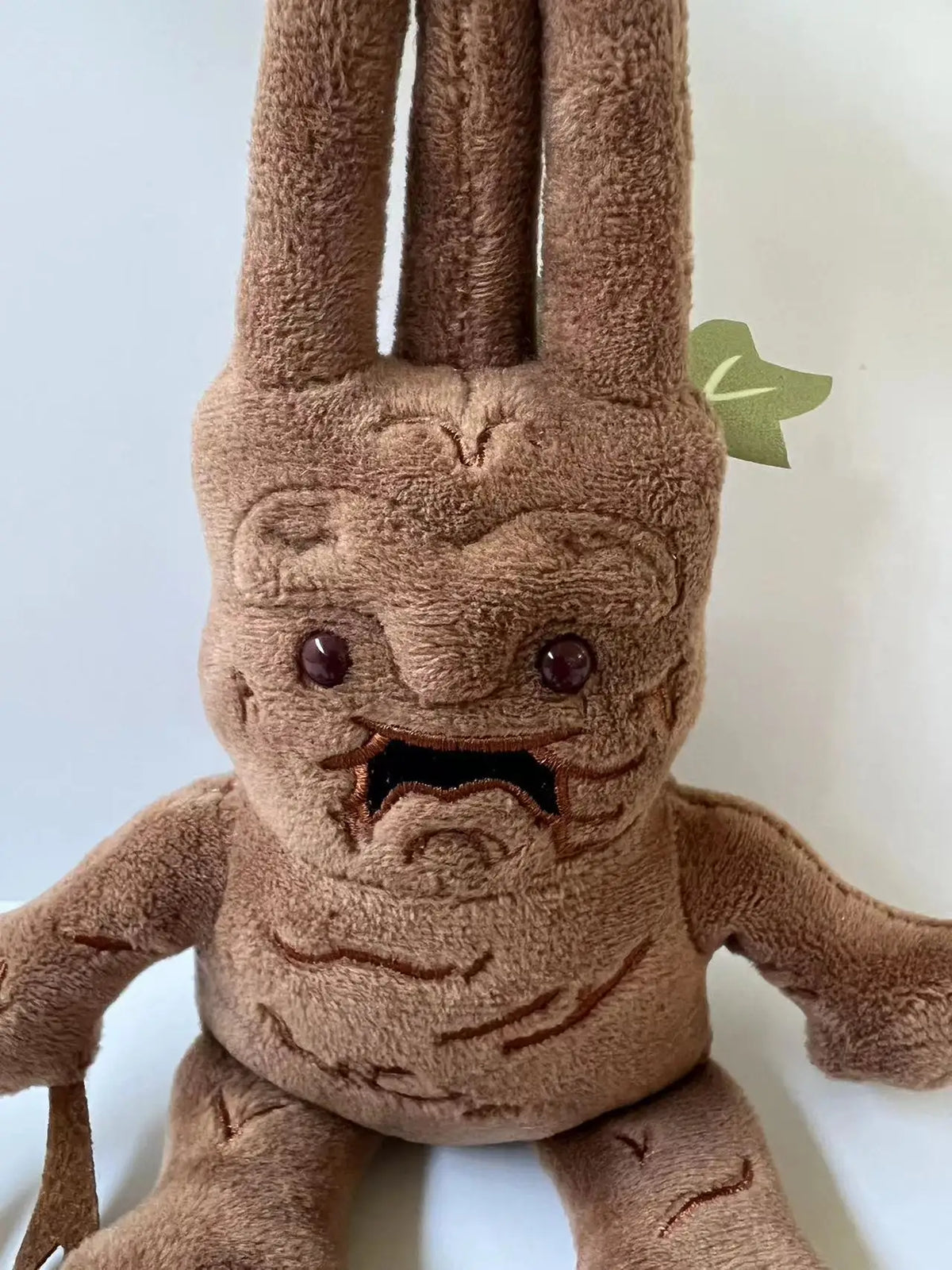 A brown Mandrake plush toy with textured skin and small facial features.