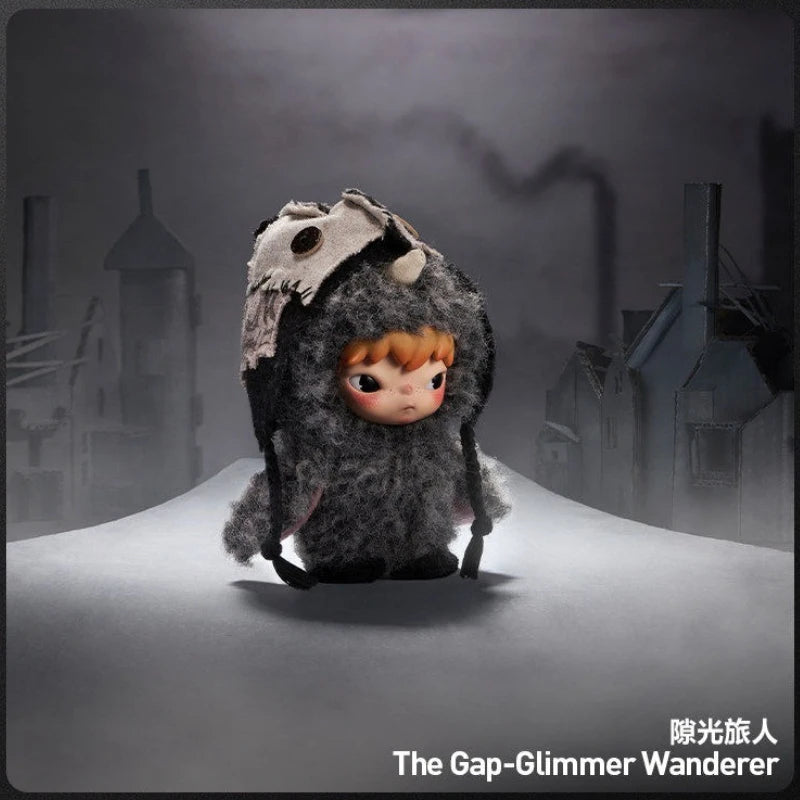 A small, dark gray plush doll with large eyes is displayed against a muted, foggy background.