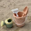 A kids sand and water play set featuring a terracotta colored bucket with a white shovel and a light green pull-along trolley