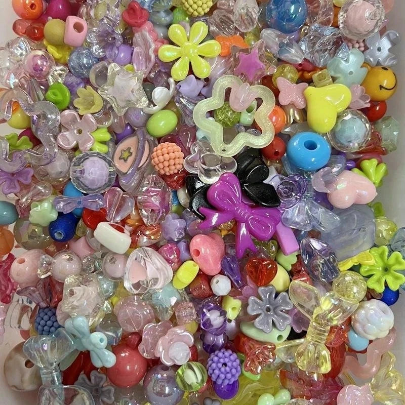 A close-up view of a large assortment of mixed colored acrylic loose beads for jewelry making