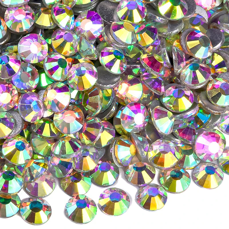 A close-up view of sparkling crystal flatback rhinestones in various shades of iridescent pink, green, and gold.