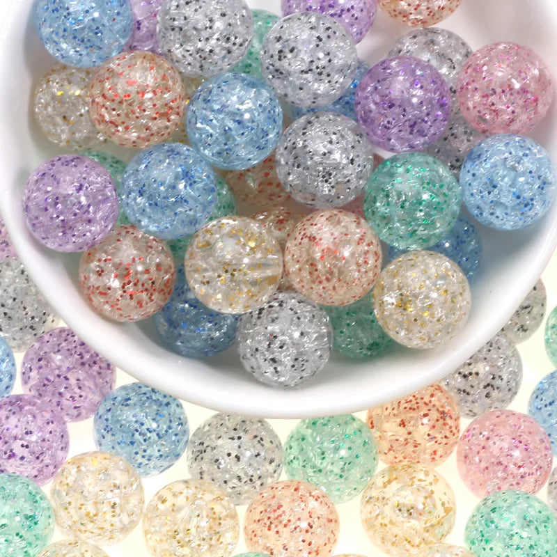 A bowl filled with various colored glitter cracked acrylic round beads for jewelry making