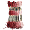 A set of six skeins of vibrant embroidery thread in shades of red, pink, and cream for cross stitch and DIY crafts.