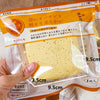 A hand holds a yellow Slow-Rise Toast Squishy Stress Relief Toy packaged in clear plastic.