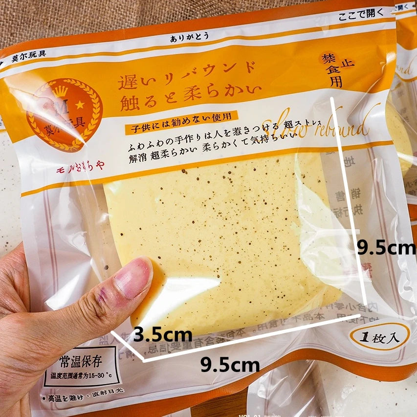 A hand holds a yellow Slow-Rise Toast Squishy Stress Relief Toy packaged in clear plastic.