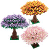 Three models of cherry blossom trees built from LEGO bricks in orange, purple, and pink.