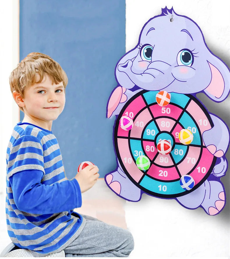 A purple cartoon elephant dart board game with sticky balls and a young boy playing.