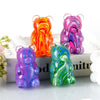 A set of four colorful gummy bear squeeze toys in various shades of orange, pink, purple, and green.