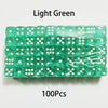 A pack of 100 light green acrylic six-sided dice with white dots, arranged in rows.