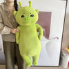 A bright lime green alien cat plush toy is held by a person in a casual indoor setting.