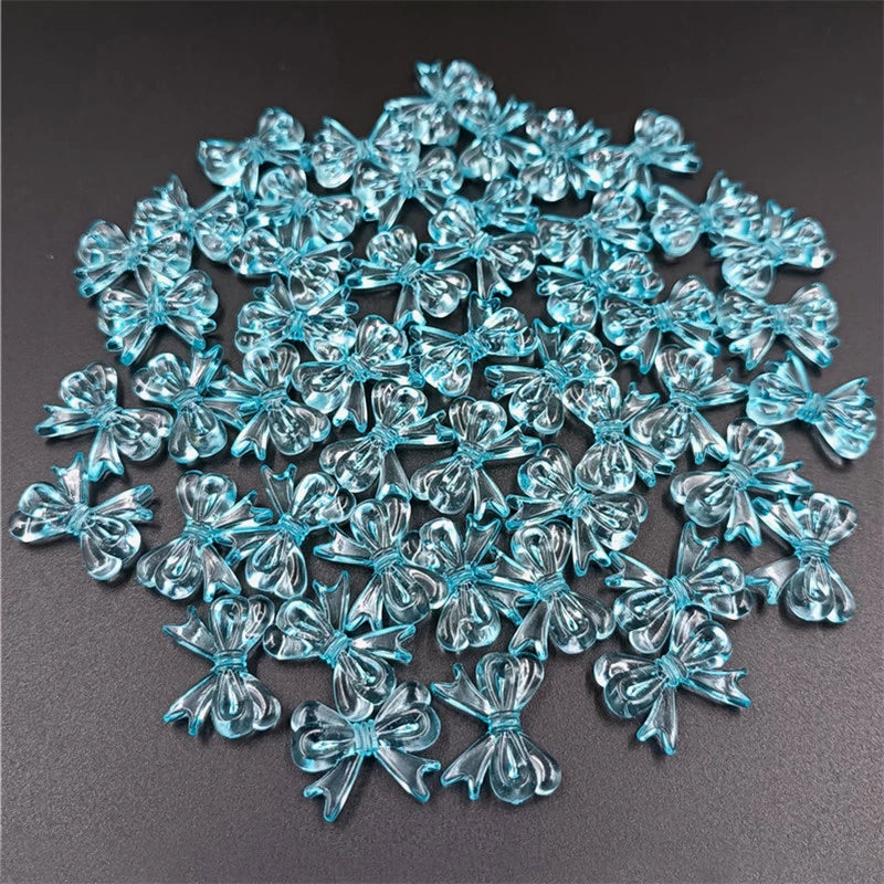 A pile of 20 clear blue acrylic bow beads for jewelry making