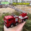 A red fire truck model with a movable ladder is held in a hand against a blurred outdoor background.