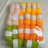 A pack of 20 skeins of milk cotton blend yarn in various shades of orange and green for knitting and crochet projects.