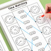 A hand is connecting time lines on a workbook to match analog clock times for early math practice.