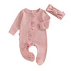 A pink knit romper for a baby girl featuring ruffled details and a matching bow headband.