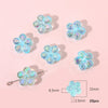 A collection of light blue acrylic flower beads for DIY jewelry making, shown with a scale.