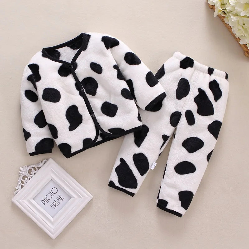 A white fleece jacket and pants set with a black cartoon print on a light beige background.