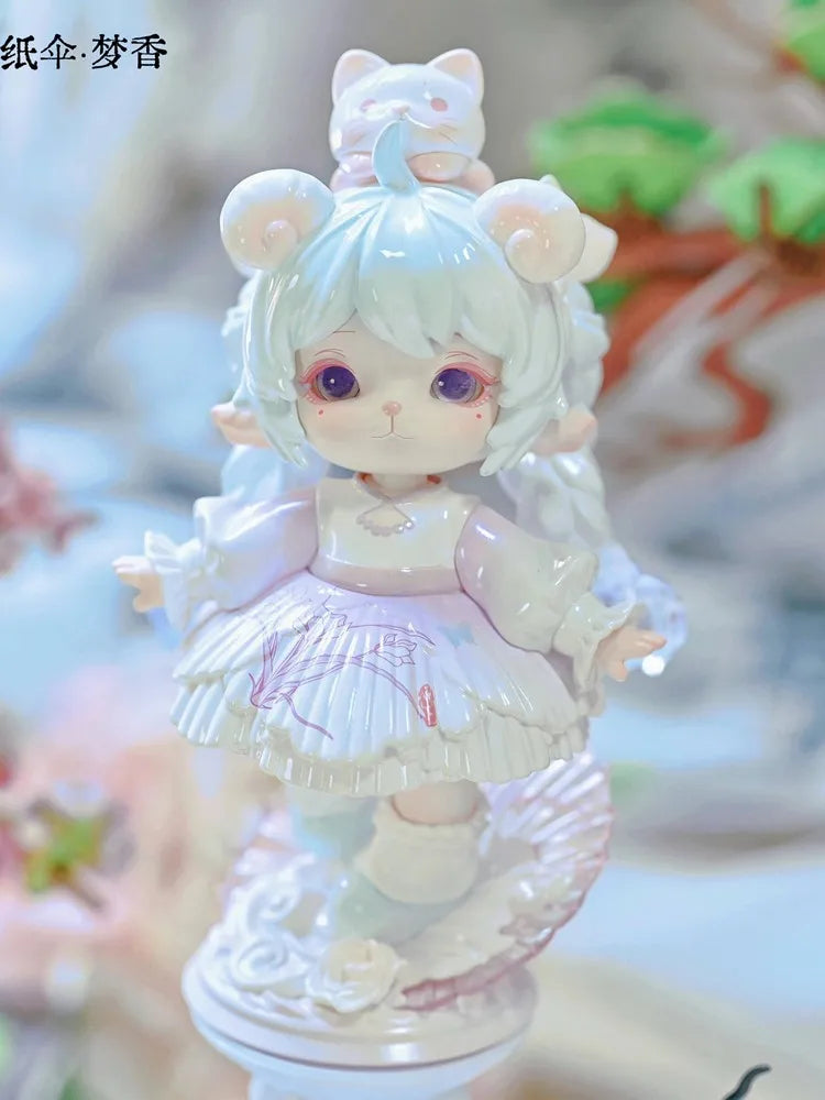 A white collectible figurine of a cat-eared girl with purple eyes and pink accents.