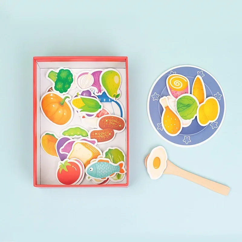 A red wooden box filled with various colorful plastic fruits and vegetables for a Montessori feeding game.