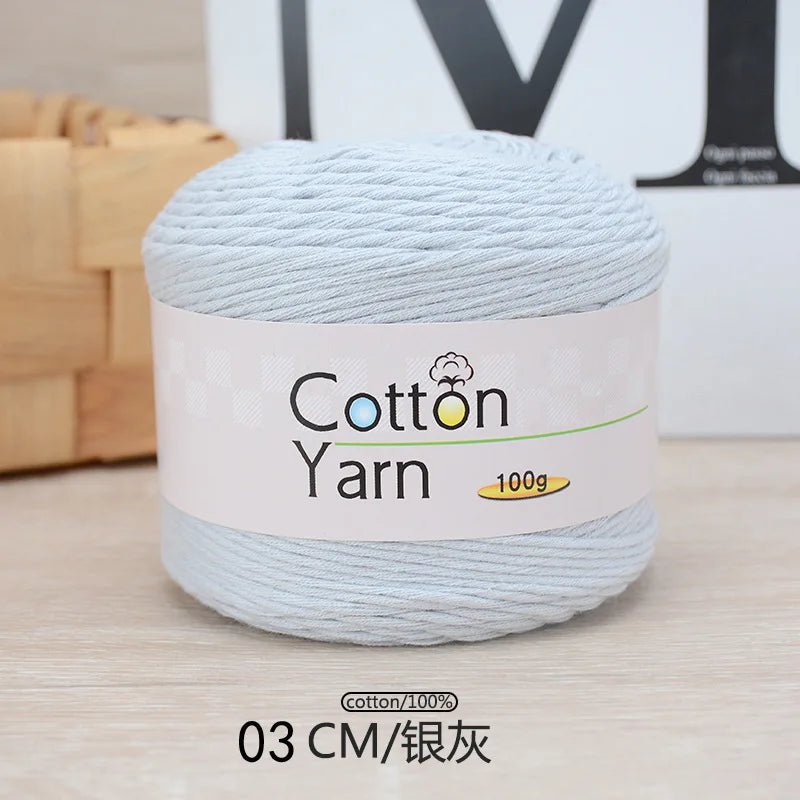 A ball of light blue cotton yarn labeled Cotton Yarn 100g with a measurement of 03 CM/silver thread.