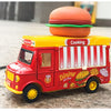 A red and yellow toy food truck shaped like a burger, featuring a large burger on top.