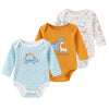 A set of three cotton baby bodysuits with long sleeves in orange, light blue, and white patterns.