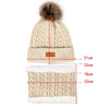 A beige knit winter hat, scarf, and gloves set with a faux fur pom.