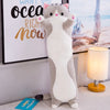 A gray and white plush cat pillow with pink ears is displayed next to a framed sign that reads Want the ocean right now.