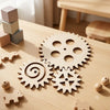 A wooden sensory activity board for toddlers featuring gears, switches, and small wooden animals on a light wood surface.