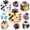 A collection of various fidget cubes and stress relief toys in silver, gold, and colorful plastic.