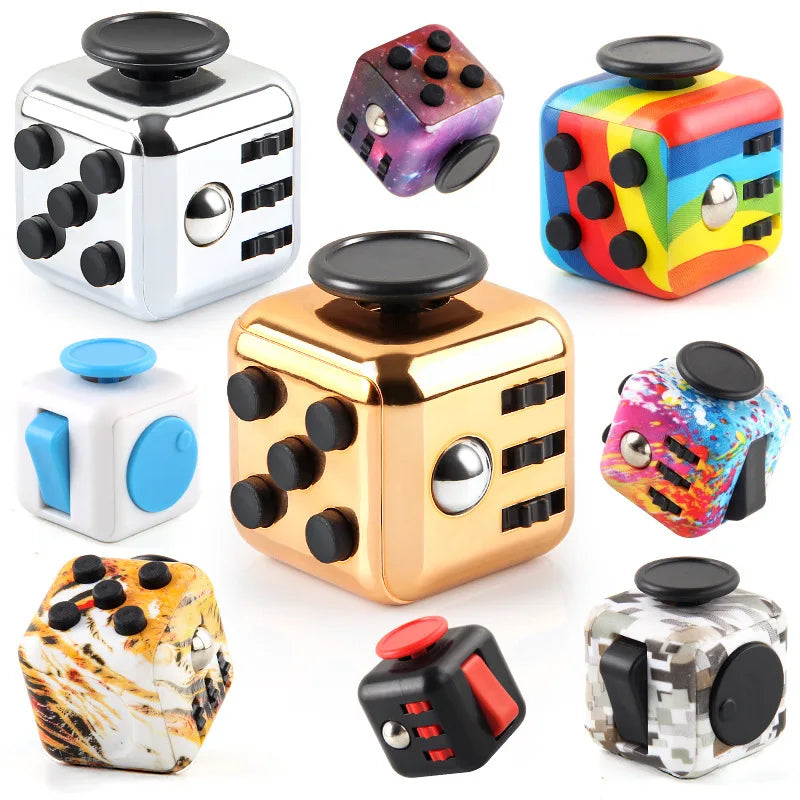 A collection of various fidget cubes and stress relief toys in silver, gold, and colorful plastic.