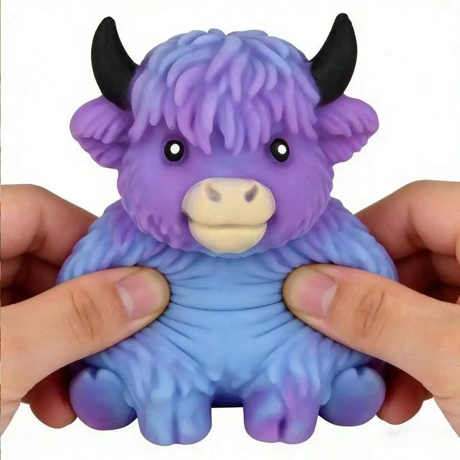 A purple and blue Scottish Highland cow squishy toy is held in a person's hands.