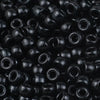 A close-up view of small, black, solid color pony beads for jewelry making and craft projects.