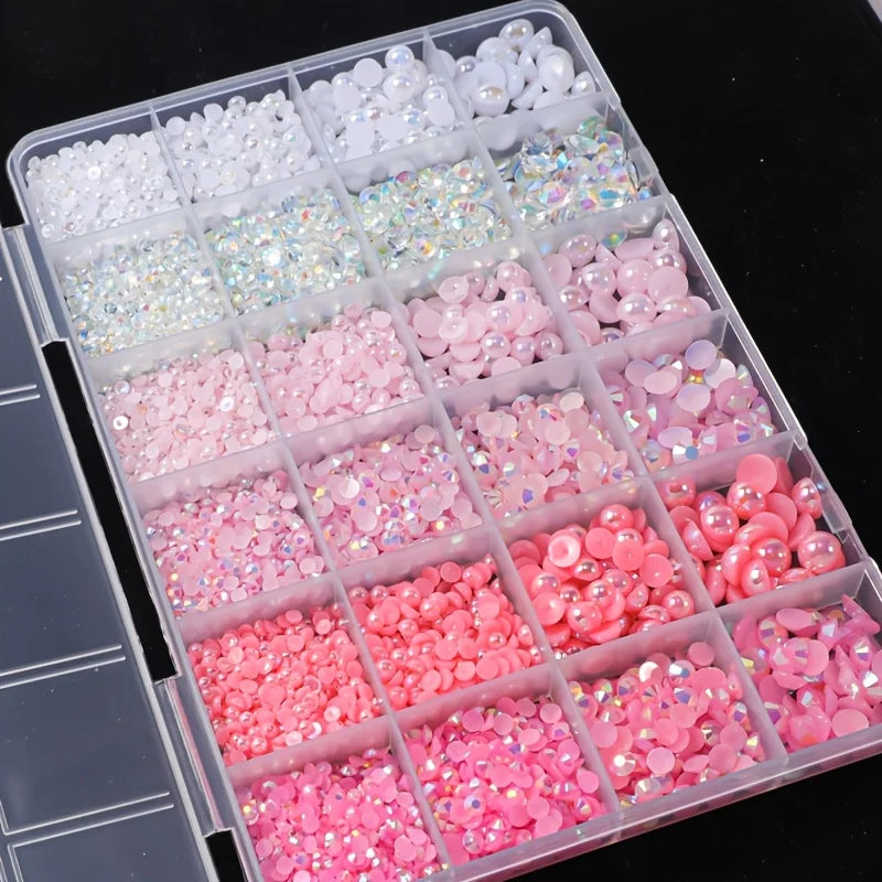 A plastic tray filled with various pink and white resin rhinestones and pearls for DIY crafts.